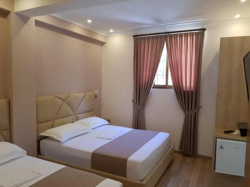 a small bedroom with a bed and a window at Guesthouse Arben Elezi in Berat