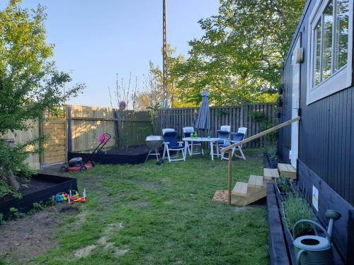 a backyard with a table and chairs and a fence at Bonjour Copenhagen in Herlev