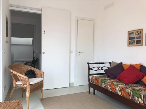 a bedroom with a bed and a wicker chair at Il Castello in Scilla