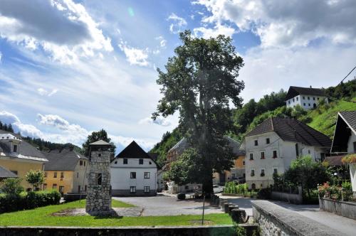 a village with a tree in the middle of a street at Wooden Cabin Kamna Gorica in Kamna Gorica
