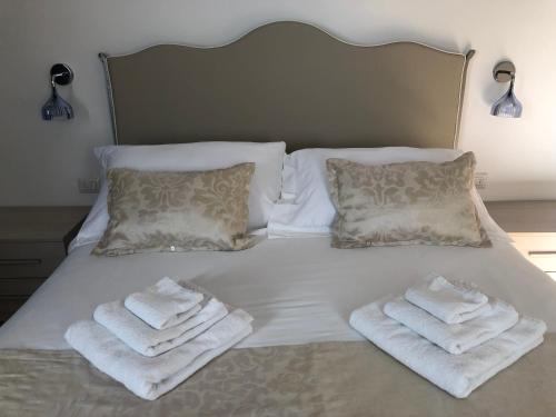 a bed with white towels on it with two pillows at B&B Dimor'à in Pitigliano