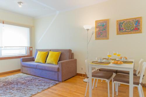 uma sala de estar com um sofá e uma mesa em Home Music Apartments no Porto