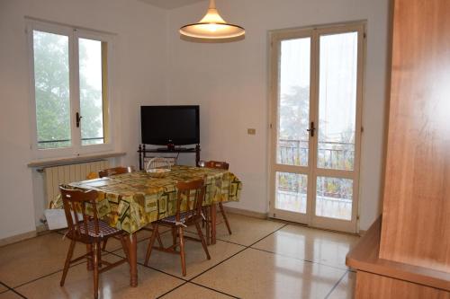 een eetkamer met een tafel met stoelen en een televisie bij Tra gli ulivi da Giacinta in Varazze