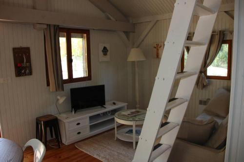 Sala de estar con escalera y TV en Il Sole, en Le Puy-Sainte-Réparade