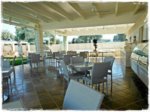 a restaurant with tables and chairs on a patio at Masseria Torre Del Diamante in Torre Canne