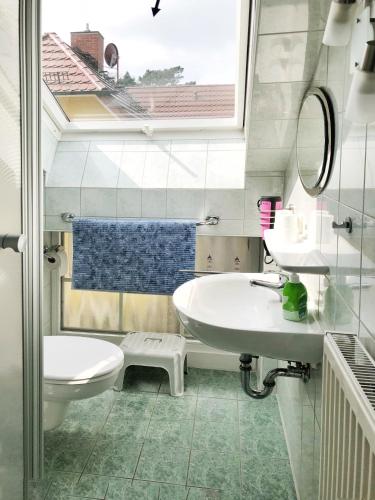 a bathroom with a sink and a toilet and a window at Ferienwohnungen Fründt in Prerow