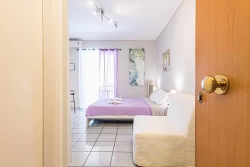 - une chambre avec un lit et une couverture violette dans l'établissement Zenios Kisamos-Pretty comfy studio, à Athènes
