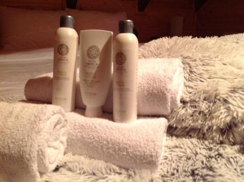 a group of three bottles of soap on a towel at Lodge House Tara in Kolašin
