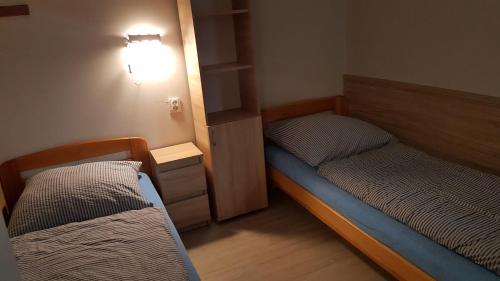 Cette chambre dispose de 2 lits et d'une lumière sur le mur. dans l'établissement Noclegi Silesia, à Tychy