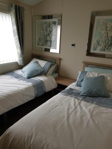 a bedroom with two beds and a window at Hot tub hols in lodge with roof terrace in Tattershall