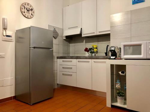 a kitchen with a stainless steel refrigerator and a microwave at T-Village502 in Anzio