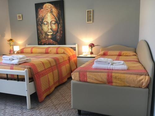 ロゼート・デッリ・アブルッツィにあるHotel Giannaのベッドルーム1室(ベッド2台付)が備わります。壁には絵画が飾られています。