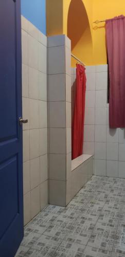 a bathroom with a mirror and a red robe at Hostel Mamallena in Panama City