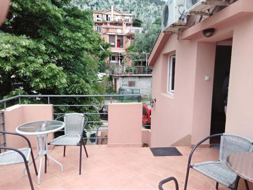 a balcony with chairs and tables on a building at Apartments Martiva in Kotor