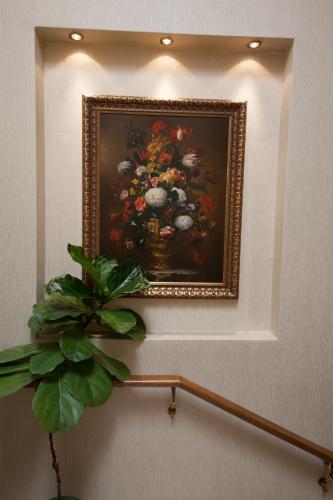 a painting of a vase of flowers on a wall at Grand Hotel London in Varna City