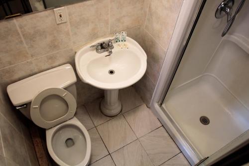 La salle de bains est pourvue de toilettes, d'un lavabo et d'une douche. dans l'établissement Hotel Casa Bella, à Montréal