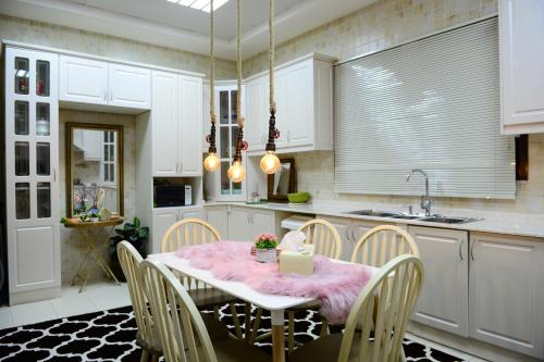 uma cozinha com uma mesa com uma toalha de mesa rosa em Kaleidoscope em Ajman