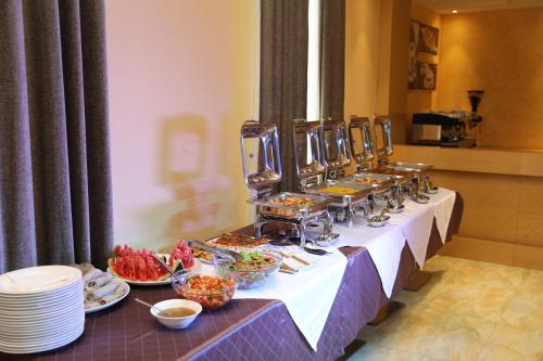 a buffet line with plates and bowls of food at Vamos Addis Hotel in Addis Ababa
