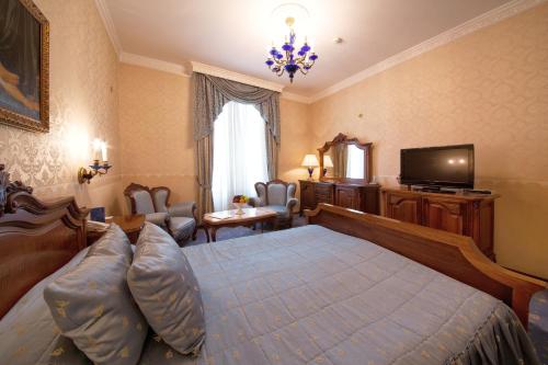 a bedroom with a large bed and a television at Grand Hotel London in Varna City