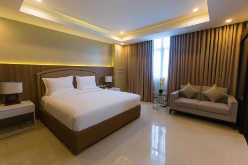 a bedroom with a large bed and a couch at Iloilo Gateway Hotel and Suites in Iloilo City