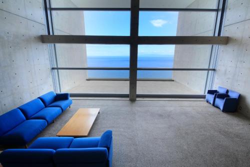 a room with blue couches and a large window at TOTO Seawind Awaji in Awaji