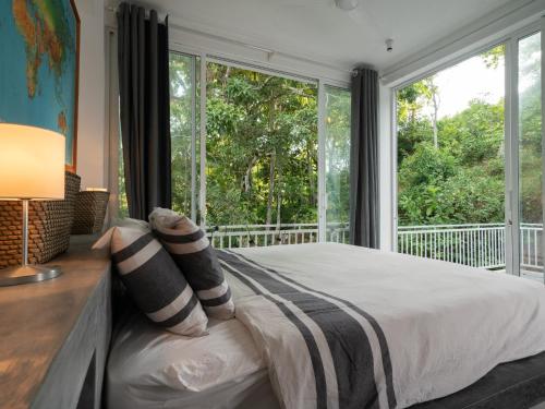 a bedroom with a bed and a large window at Villa Siriwimal in Weligama