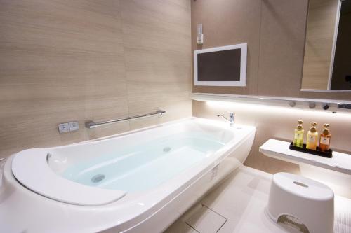 淡路的住宿－托託海風淡路酒店，白色的浴室设有浴缸和卫生间。