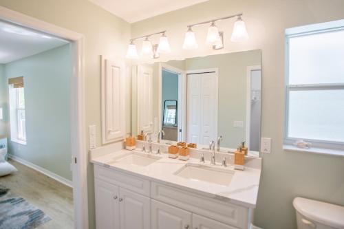 a bathroom with two sinks and a large mirror at Stunning Newly Designed and Renovated Home seconds to the Gulf Of Mexico in Sanibel