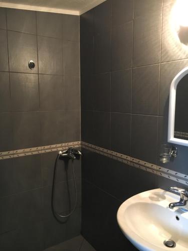 a bathroom with a shower and a sink at Дървени къщички - Лион in Sinemorets