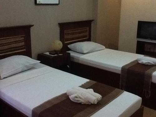 a hotel room with two beds with towels on them at Darunday Manor in Tagbilaran City