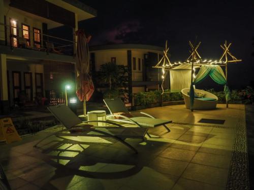 two chairs and a table on a patio at night at Luz_ita Sunshine Villa in Uluwatu