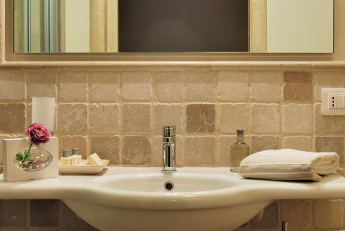 a bathroom sink with a flower and a mirror at Masseria Torre Del Diamante in Torre Canne