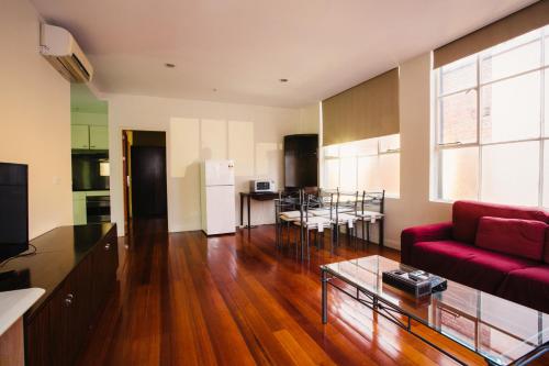 sala de estar con sofá rojo y mesa en YTI Garden Hotel, en Melbourne