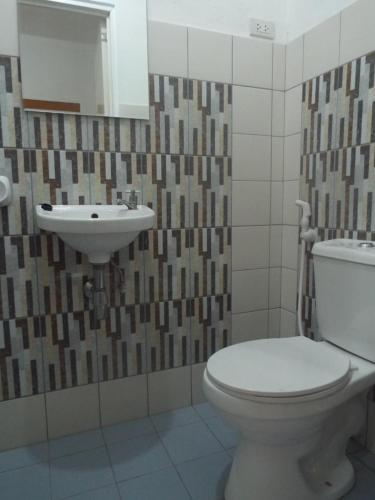 a bathroom with a toilet and a sink at Sablayan Gustav's Place Silver Beach Dive Resort in Sablayan
