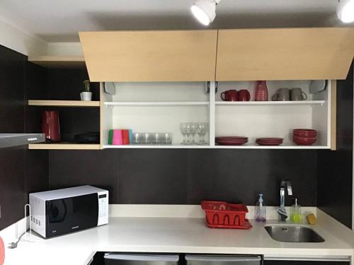 a kitchen with a microwave and a counter top at Moderno departamento Miraflorino con aire acondicionado in Lima