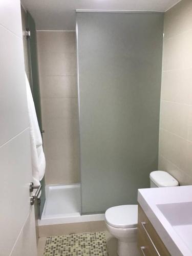 a bathroom with a shower and a toilet and a sink at Moderno departamento Miraflorino con aire acondicionado in Lima