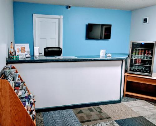 a bar in a room with a refrigerator and a tv at Executive Inn in Thomson