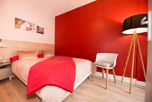 ル・アーヴルにあるAppartement Élégant & Ensoleillé - Centre-villeの赤いベッドルーム(ベッド1台、椅子付)