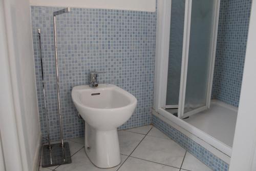 a bathroom with a toilet and a shower and a sink at Cortile Maggiore Home in Cefalù