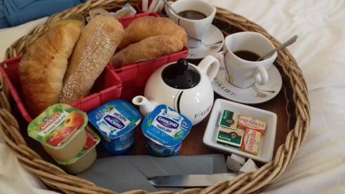 a basket filled with breakfast foods and cups of coffee at Chambres Du Petit Bonheur in Biscarrosse