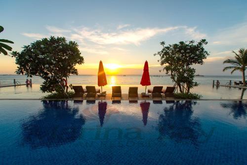 uma piscina com cadeiras e guarda-sóis em frente ao oceano em Marina Bay Vung Tau Resort & Spa em Vung Tau