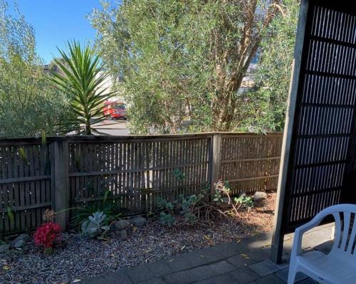 a patio area with a fence and a fence post at Wrights by the Sea Motel in Paraparaumu Beach