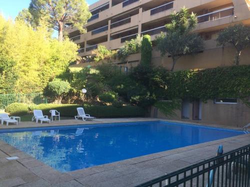 una piscina con due sedie e un edificio di AZURELLE a Nizza