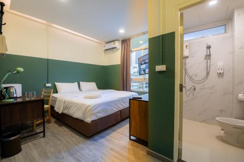 a bedroom with a bed and a bathroom with a shower at Spacy BKK in Bangkok