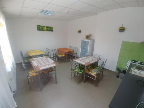 an empty room with tables and chairs and a refrigerator at Camere De Inchiriat Carpati in Hunedoara