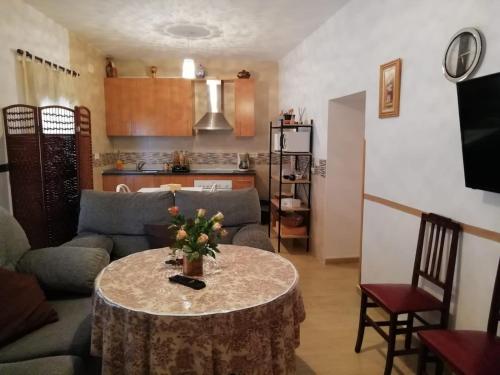 ein Wohnzimmer mit einem Tisch mit Blumen darauf in der Unterkunft Casa Simona in Navas de Estena