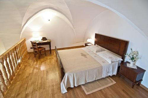 een slaapkamer met een bed en een tafel met een bureau bij Home Holiday Salento Casa Agrosì in Supersano