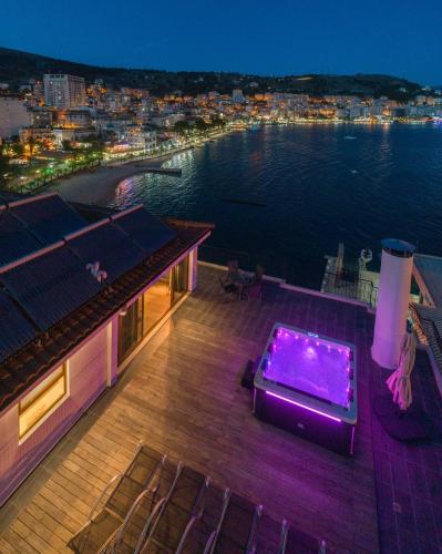 a deck with a hot tub on top of a house at PALMA city HOTEL in Sarandë