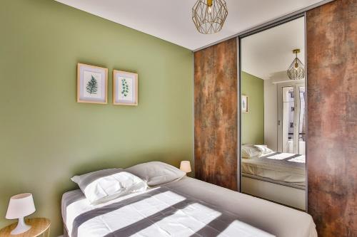 une chambre avec un lit et un miroir dans l'établissement Rossini Centre Ville - Proche Tram, à Nice