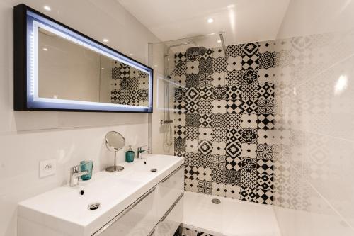 une salle de bain blanche avec un lavabo et un miroir dans l'établissement Rossini Centre Ville - Proche Tram, à Nice